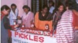 Photograph of women selling jars of pickle